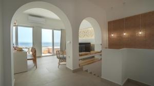 霍拉斯法基翁Sfakia Seaside luxury Suites的带拱门的厨房和海景用餐室
