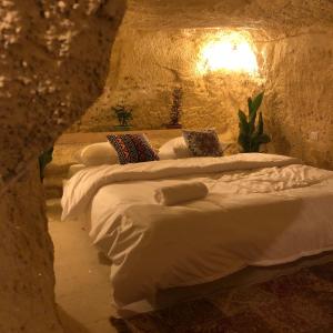Al Jāyah7 Caves Hotel的石头房里三张床