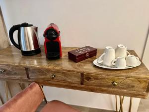 罗马Relais Roma Vaticano - METRO station Ottaviano的咖啡壶和木桌上的杯子