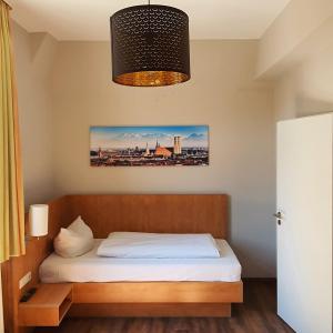格赖茨Hotel Friedensbruecke的一间卧室配有一张床和一个吊灯