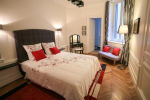 里昂拉斯特兰特瑞尼公寓的一间卧室配有一张带红色枕头的大床