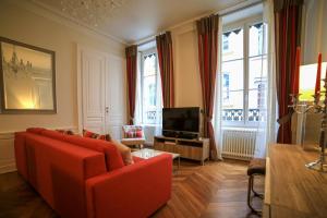 里昂拉斯特兰特瑞尼公寓的客厅配有红色沙发和电视
