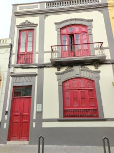大加那利岛拉斯帕尔马斯Adara Vegueta Exclusive Apartment的一座带红色门和阳台的建筑