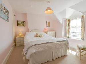 以撒港Agar Cottage的卧室配有白色的床和窗户。