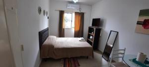 圣地亚哥-德尔埃斯特罗TU REFUGIO - Alquiler Temporario的一间卧室配有一张床、一张桌子和一个窗户。