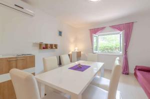 普利格拉迪卡Holiday home in Blato Insel Korcula 6411的白色的饭厅设有白色的桌子和窗户