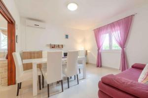 普利格拉迪卡Holiday home in Blato Insel Korcula 6411的白色的用餐室配有桌椅