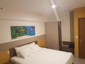 奥林匹亚Apartamento no Olímpia Park Resort (Melhor preço!)的卧室配有白色的床和墙上的绘画作品
