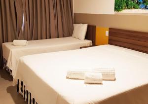 奥林匹亚Apartamento no Olímpia Park Resort (Melhor preço!)的客房内的两张床和白色床单