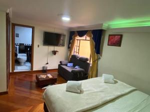 波哥大Hotel L&L Mansión的一间卧室配有一张床,客厅配有沙发