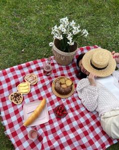 梅斯蒂亚Bude Mestia cottages的一位躺在野餐毯上吃着食物的女人