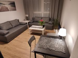 格但斯克MustSEA Gdańsk Apartments with underground parking的客厅配有桌子和沙发