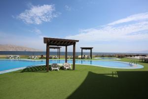 海塞卜阿塔那海塞卜酒店的草地上带两把椅子的游泳池的 ⁇ 染