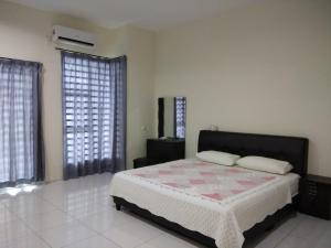 怡保Fong's Ipoh SImpang Pulai Homestay的一间卧室设有一张床和两个窗户。