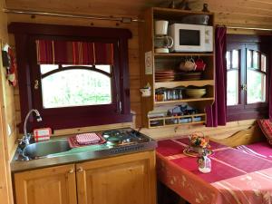 Outines埃尔夫斯大篷车度假屋，隐秘之地的厨房设有水槽、窗户和柜台。