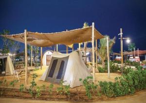 阿布扎比Bab Al Nojoum Hudayriyat Camp的夜间公园里的帐篷和滑梯