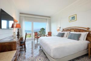 索伦托德拉维尔大酒店的一间卧室配有一张床、一张书桌和一个窗户。