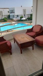 沙姆沙伊赫Juliee House-Criss Resort-Naama Bay的一个带桌椅的庭院和一个游泳池