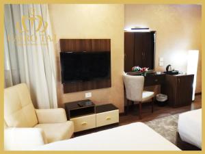 开罗Cairo Taj Dokki Families Tower的酒店客房配有一张床、一台电视和一张书桌。