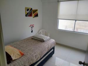 蓬塔赫尔莫萨Departamento en Punta Hermosa con Vista al Mar的白色的卧室设有床和窗户