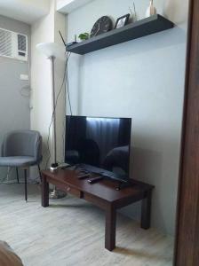 曼达维市Cozy Condominium near Mactan International Airport的客厅的桌子上配有电视