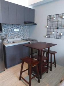 曼达维市Cozy Condominium near Mactan International Airport的厨房配有桌子和两张凳子