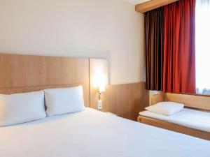 布拉尼亚克ibis Toulouse Aeroport的酒店客房设有床和窗户。