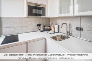 德累斯顿"Neptunblick"- Nähe Altstadt - Ruhig - Klinikum的厨房配有白色橱柜和水槽