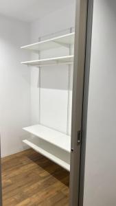 奥洛穆茨Kamel club restaurace a penzion的衣柜配有白色架子和木地板