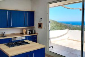 RoglianoRogliano Maison de charme avec vue panoramique的一间设有蓝色橱柜的厨房,享有海景