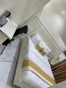 伊凯贾LUXOL HOMES&SUITES的一间卧室配有带白色床单和枕头的床。