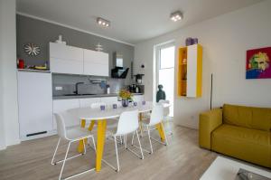 格洛韦Albert-INN-Glowe - barrierefrei & 3 Schlafzimmer & Coworking & Strandkorb-saisonal & Sauna im Haus & Fahrräder的厨房以及带桌椅的起居室。