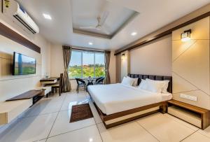 戈尔哈布尔Hotel Grand Indu, 3 Star Kolhapur的配有一张床、一张桌子和一张桌子的酒店客房