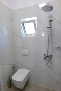 萨兰达Saranda Landscape的白色的浴室设有卫生间和窗户。