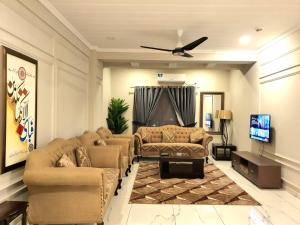 拉瓦尔品第The Millenial Apartments & Suites Bahria Town的带沙发和平面电视的客厅