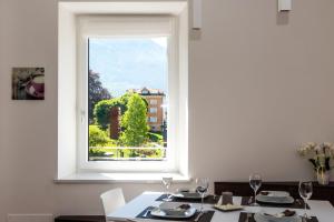 莱维科特尔梅Appartamento Levico的一间带窗户和桌椅的用餐室