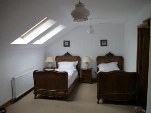 MoniaiveOld Coach House的一间卧室配有两张床和两把椅子