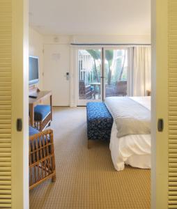阿瓦隆圣廷苑酒店的一间卧室配有一张床、一张书桌和一台电视