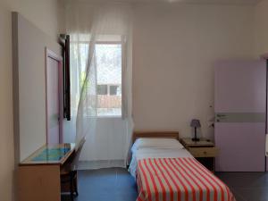 伊斯基亚Hotel Villa Cecilia的一间卧室配有一张床、一张书桌和一个窗户。
