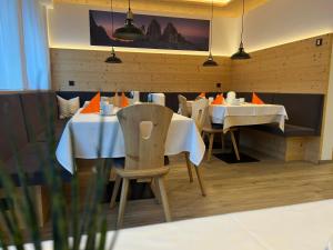 布鲁尼科B&B Obermair的用餐室配有白色的桌椅和灯光