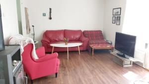 瓦根Cottage Halle-Hunneberg的客厅配有红色的沙发和桌子
