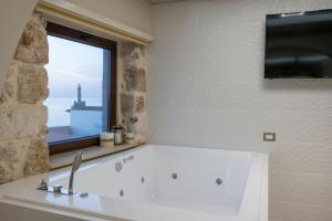 干尼亚La vista de Pablo的一间带大型白色浴缸及窗户的浴室