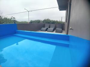 三芝乡海灣旅宿的享有蓝色游泳池的景致,配有2把椅子