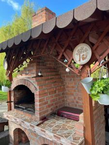 霍雷祖Pensiunea Broscuta的室外砖炉,有屋顶和植物