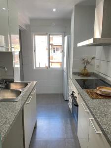 波多黎多德萨贡托UIM Mediterraneo Alicante Wifi的白色的厨房配有水槽和冰箱