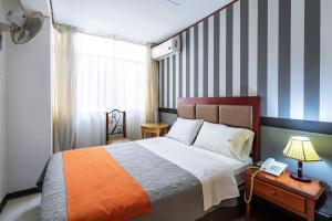 特鲁希略Recreo Hotel的一间卧室配有一张带条纹墙的床