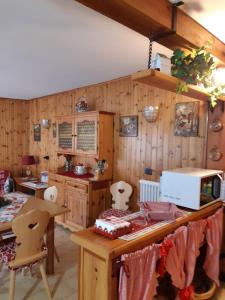坎皮泰洛迪法萨Sella Ronda Apartment的厨房设有木墙和一张带微波炉的桌子。