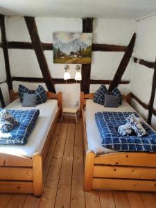 萨森海姆Gemütliche Gästezimmer in einem neu sanierten Fachwerkhaus的铺有木地板的客房内的两张床