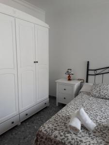 巴尔巴特Piso Tarayuela的卧室配有白色橱柜和1张带2条毛巾的床