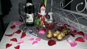 诺维萨德Prenoćište Luna 2005的一张桌子,上面放着一瓶葡萄酒和酒杯,还有红花